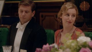 Allan Leech and Laura Carmichael sit looking unamused at dinner in Downton Abbey.