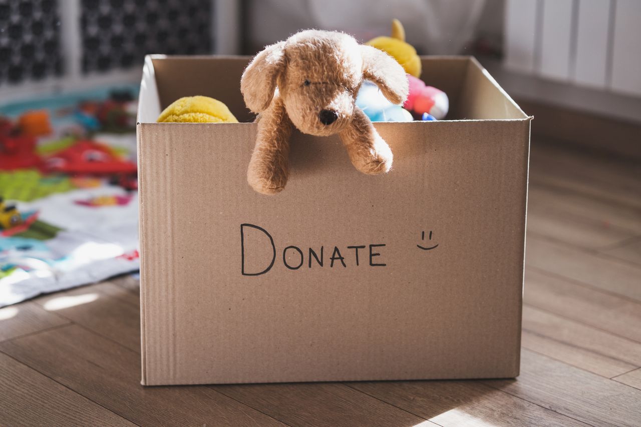 Donation cardboard box with children&#039;s clothes and toys for a charity.