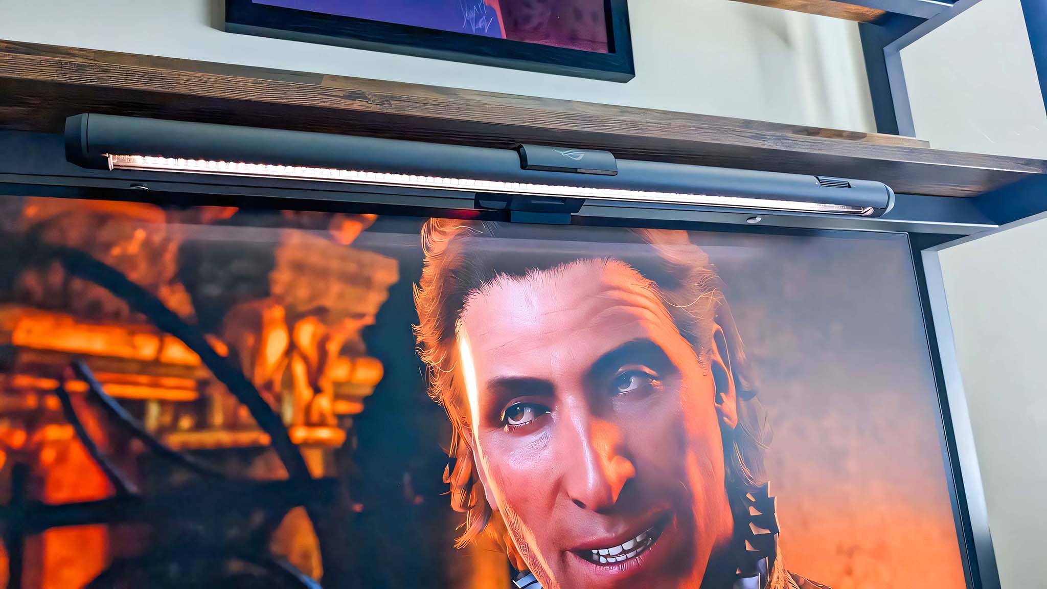 ASUS ROG Aura Monitor Light Bar placed above the monitor and shining white light down. Baldur's Gate 3's Raphael is on the screen. 