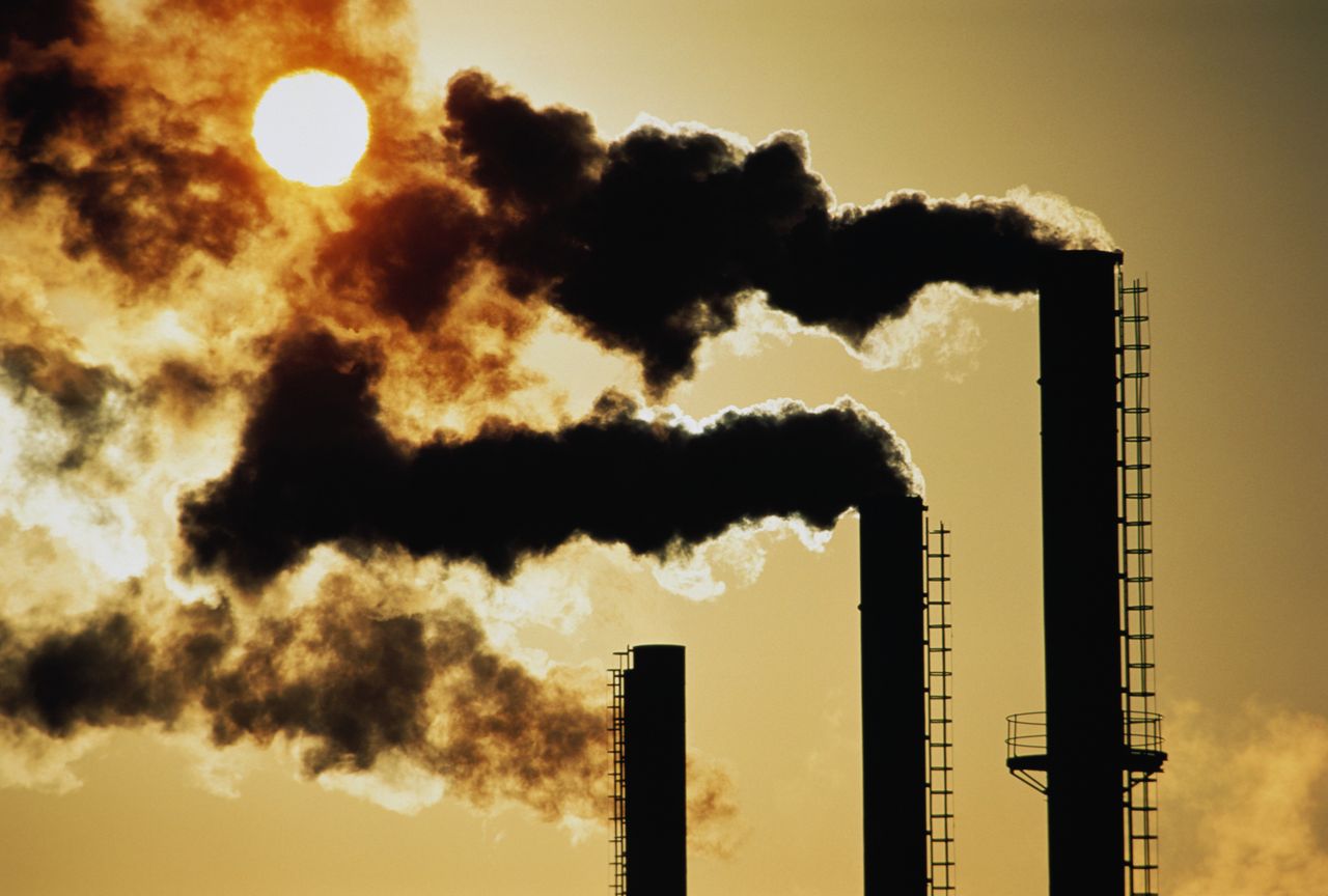 Trio of industrial chimneys emitting smoke.