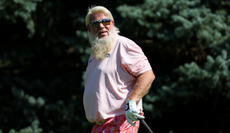 John Daly watches his golf ball after striking it off the tee