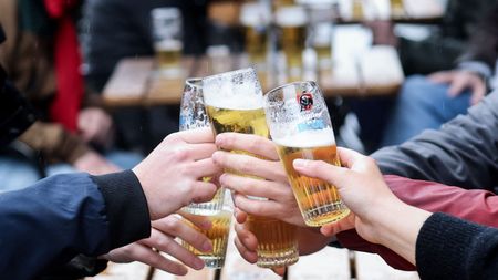 Friends clink glasses outside a pub