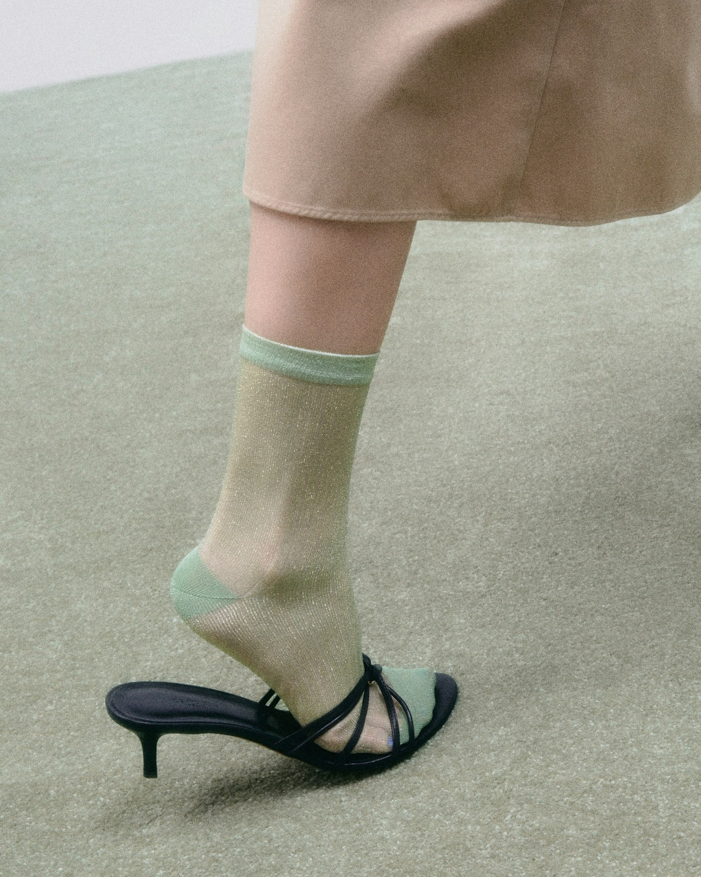 Model wearing green sheer sock and black Le Monde Beryl shoe.