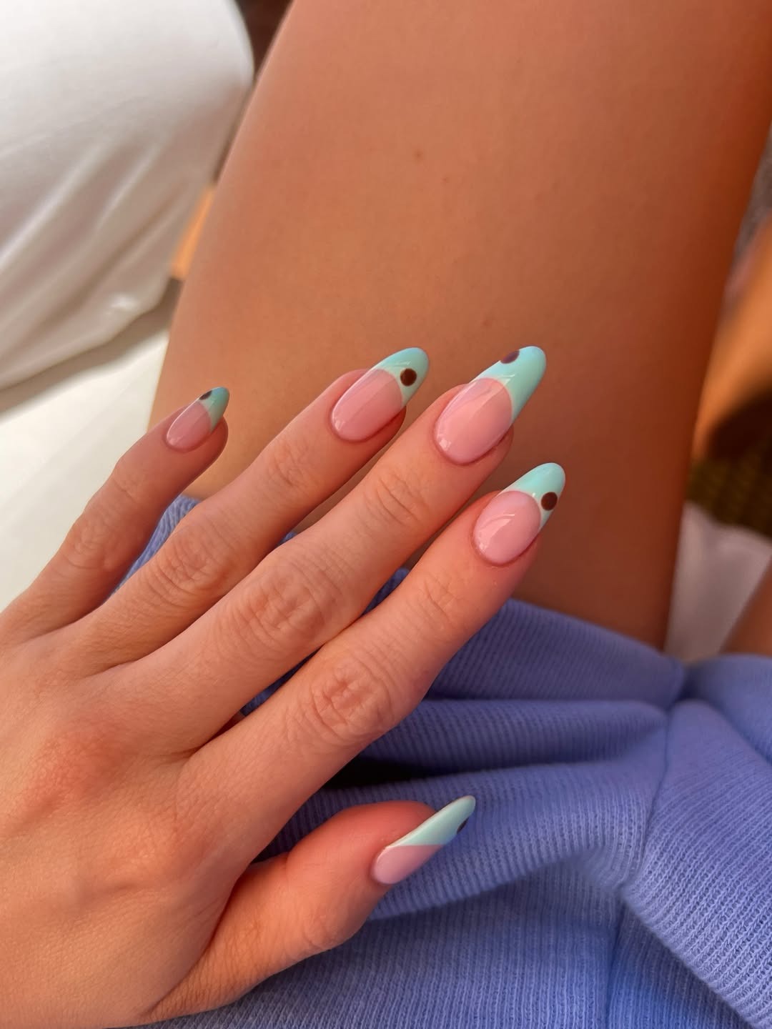 A picture of long, almond-shaped nails with turquoise French tips