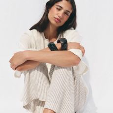 Woman wears white t-shirt, white striped trousers