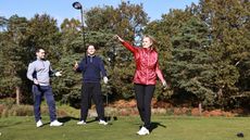 a golfer throwing a golf club while two other golfers behind look unimpressed