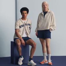 Two models wearing New Balance clothing and trainers