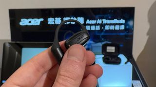 Acer AI TransBud in hand with Acer logo on board in background