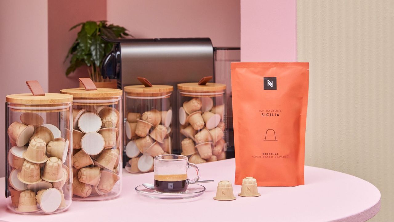 Nespresso paper capsules in jars on a countertop with a coffee bag