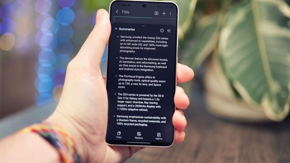 Samsung Galaxy S24 phone held in a hand with the screen showing text on a black background