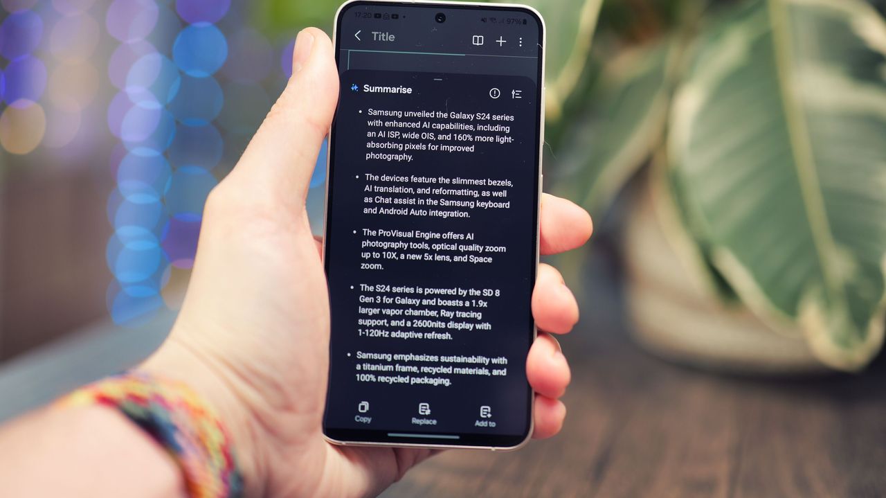 Samsung Galaxy S24 phone held in a hand with the screen showing text on a black background