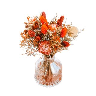 A bouquet of fall dried flowers in a glass vase
