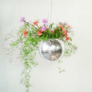 Disco ball planter with flowers in it