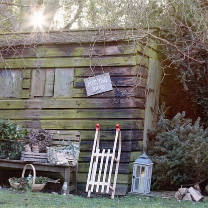 Garden shed in winter with potting shed sign