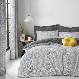 bedroom with bed with cushion and white walls
