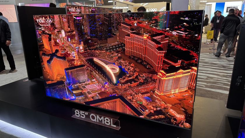 TCL C8L QM8L on stand with cityscape on screen