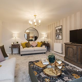 living room with cream colour strip wall sofa with designed cushion and chandelier