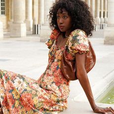 a photo of a woman wearing a printed dress with florals