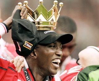 Dwight Yorke wears the crown from the Premier League trophy on his head after winning the 1998/99 title with Manchester United