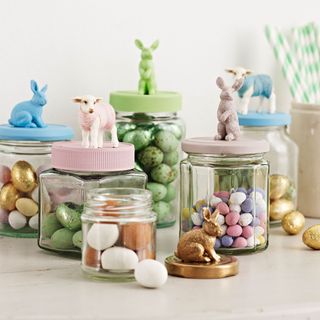 painted glass jars with toy figures on lids