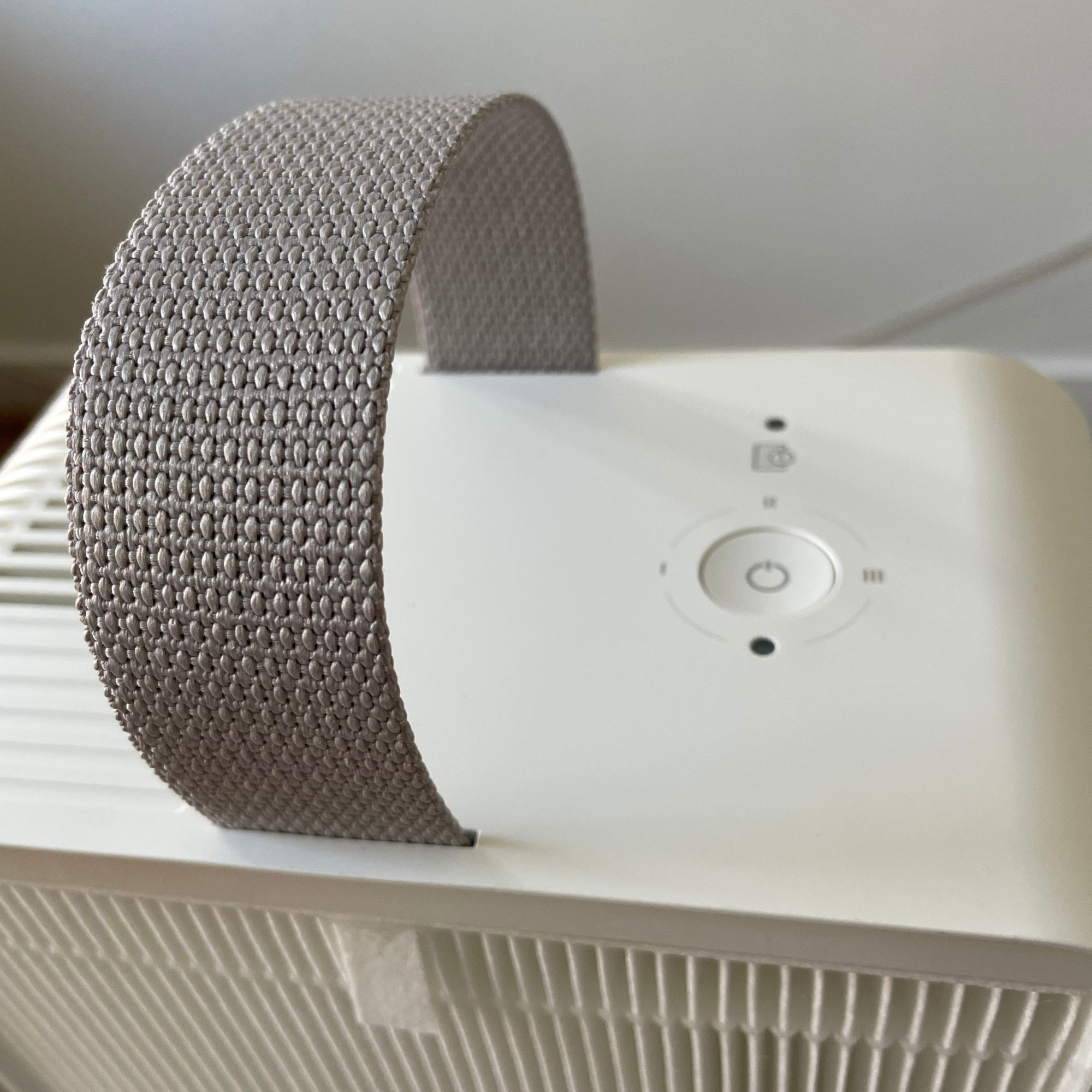 looking at the top of the IKEA UPPÅTVIN air purifier, including the grey handle and the buttons