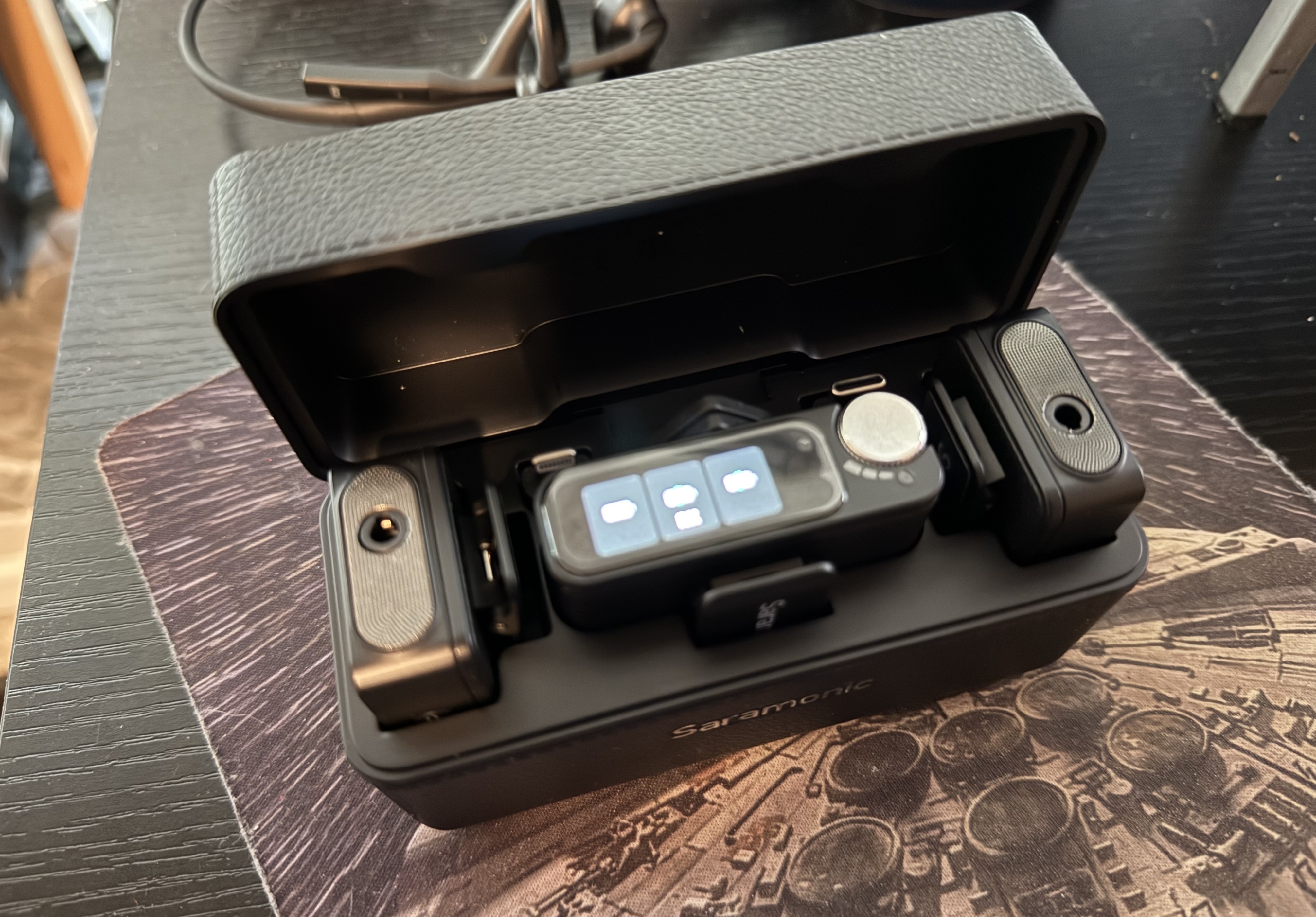 The Saramonic Ultra wireless mics in its charging case in black.