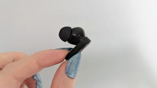 OnePlus Nord Buds review: earbud held up against a wall