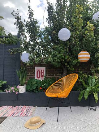 yellow chair from cult furniture with black painted raised beds on patio