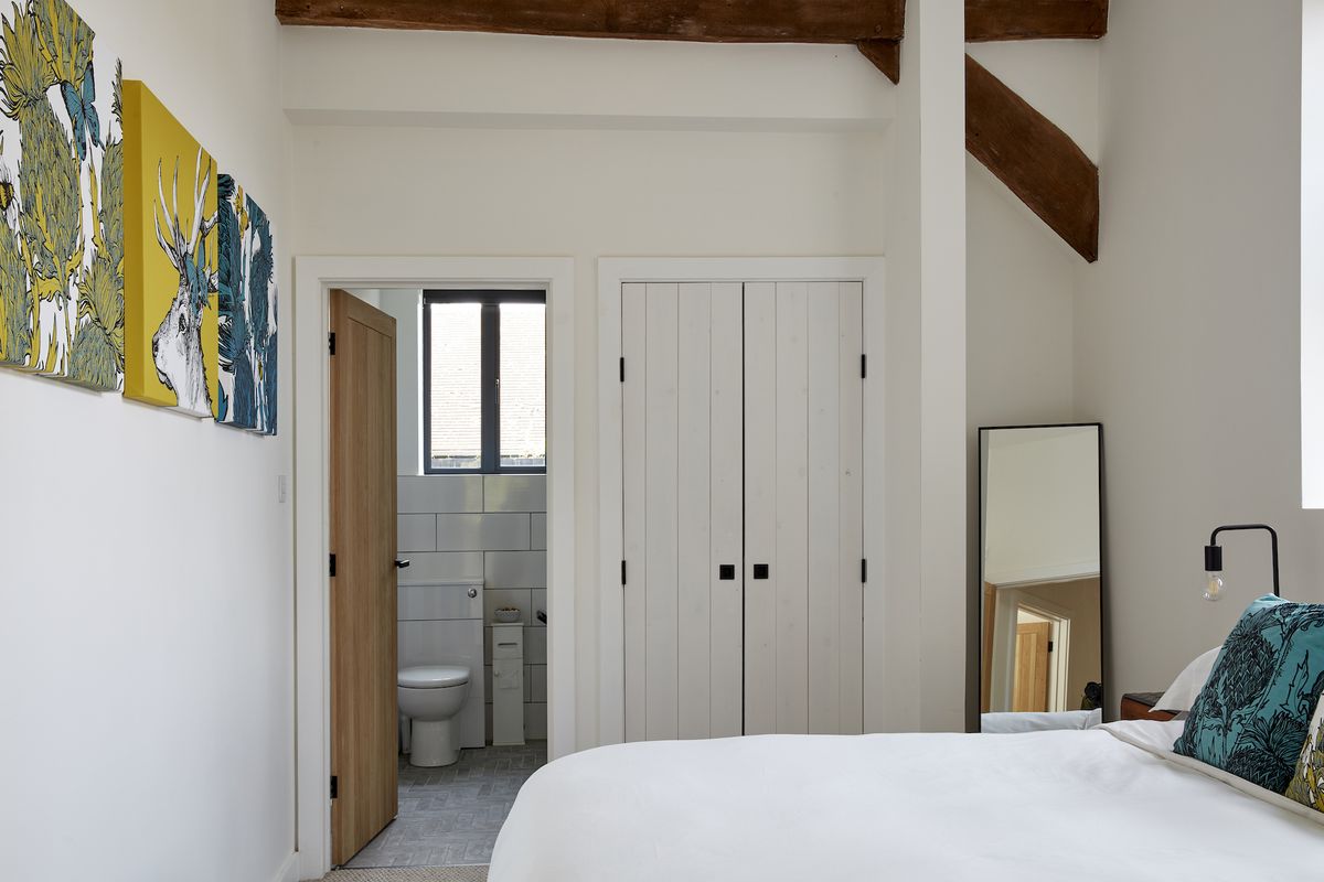 modern white bedroom with view to en suite