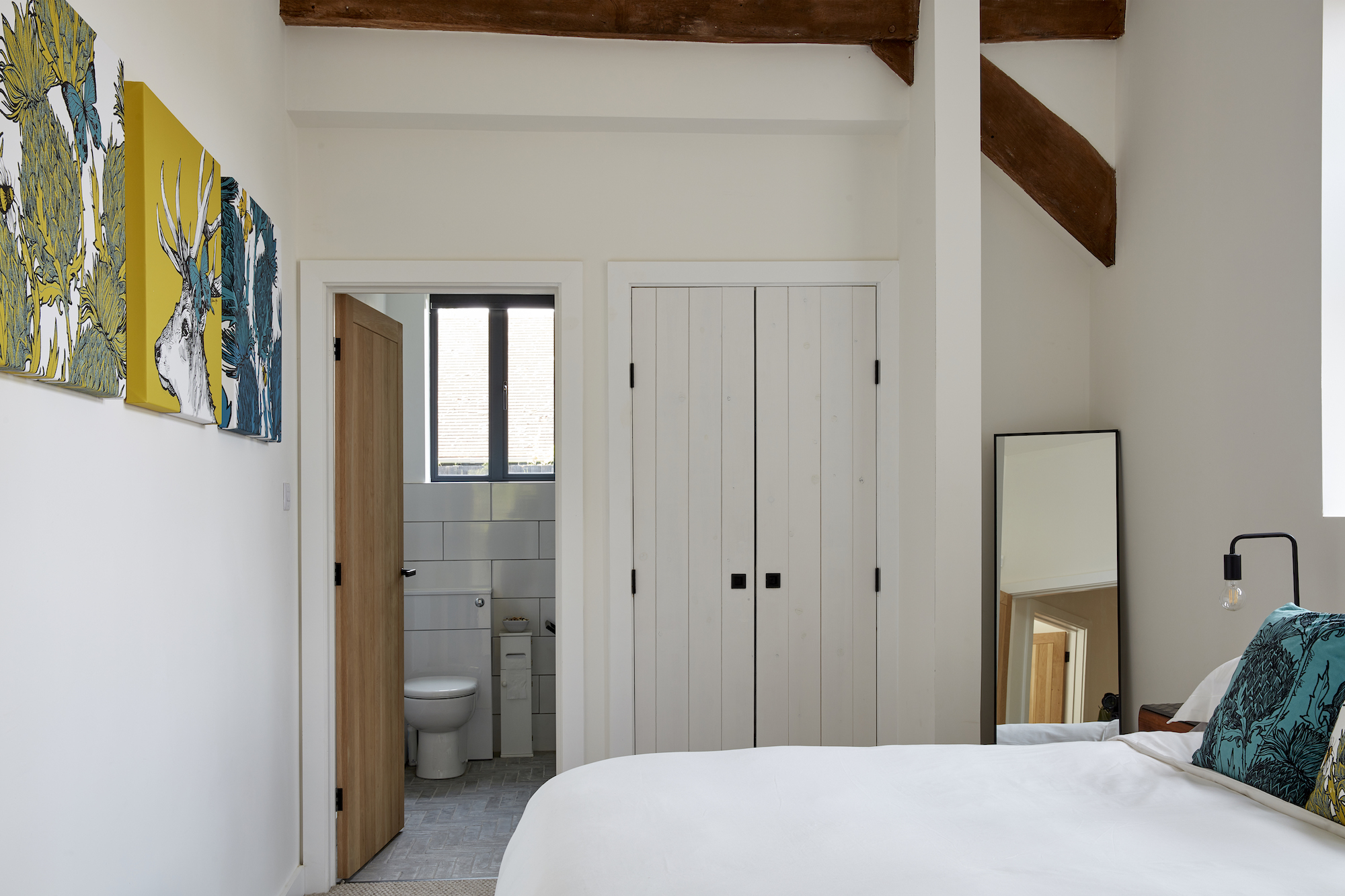 modern white bedroom with view to en suite