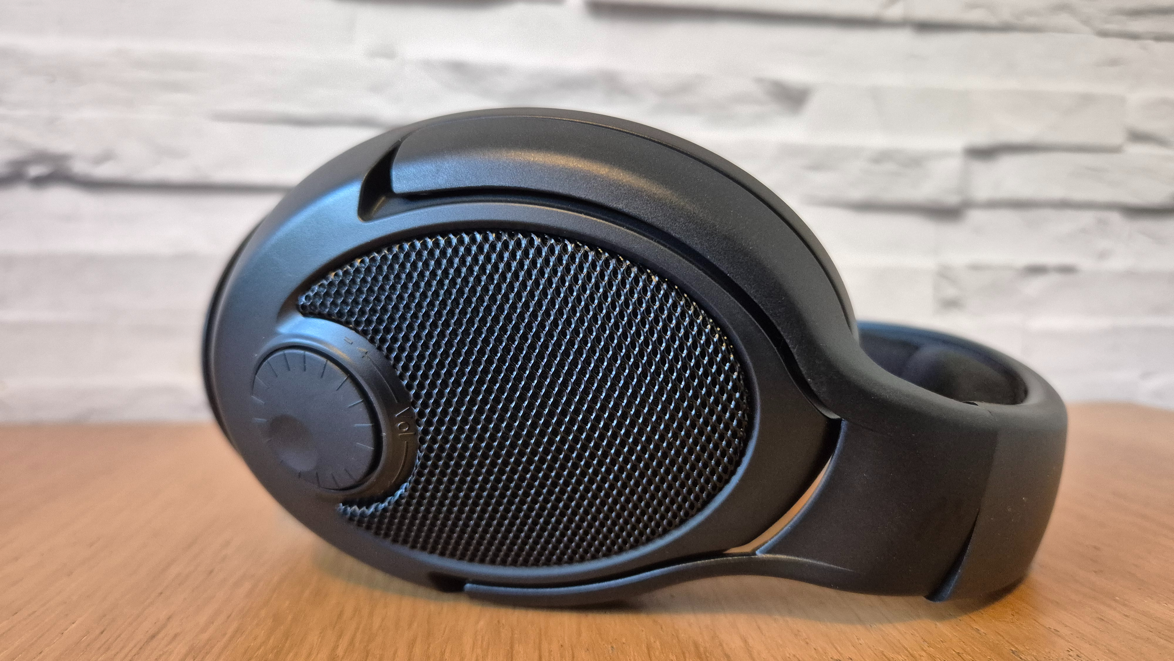 The Drop + Epos PC38X headset on a wooden surface in front of a white brick wall