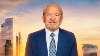 Lord Alan Sugar in a navy blue suit and tie with a white shirt posed in front of a mocked up image of London at sunrise.