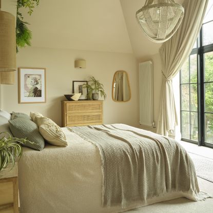 A light airy bedroom with a the bed facing a large window