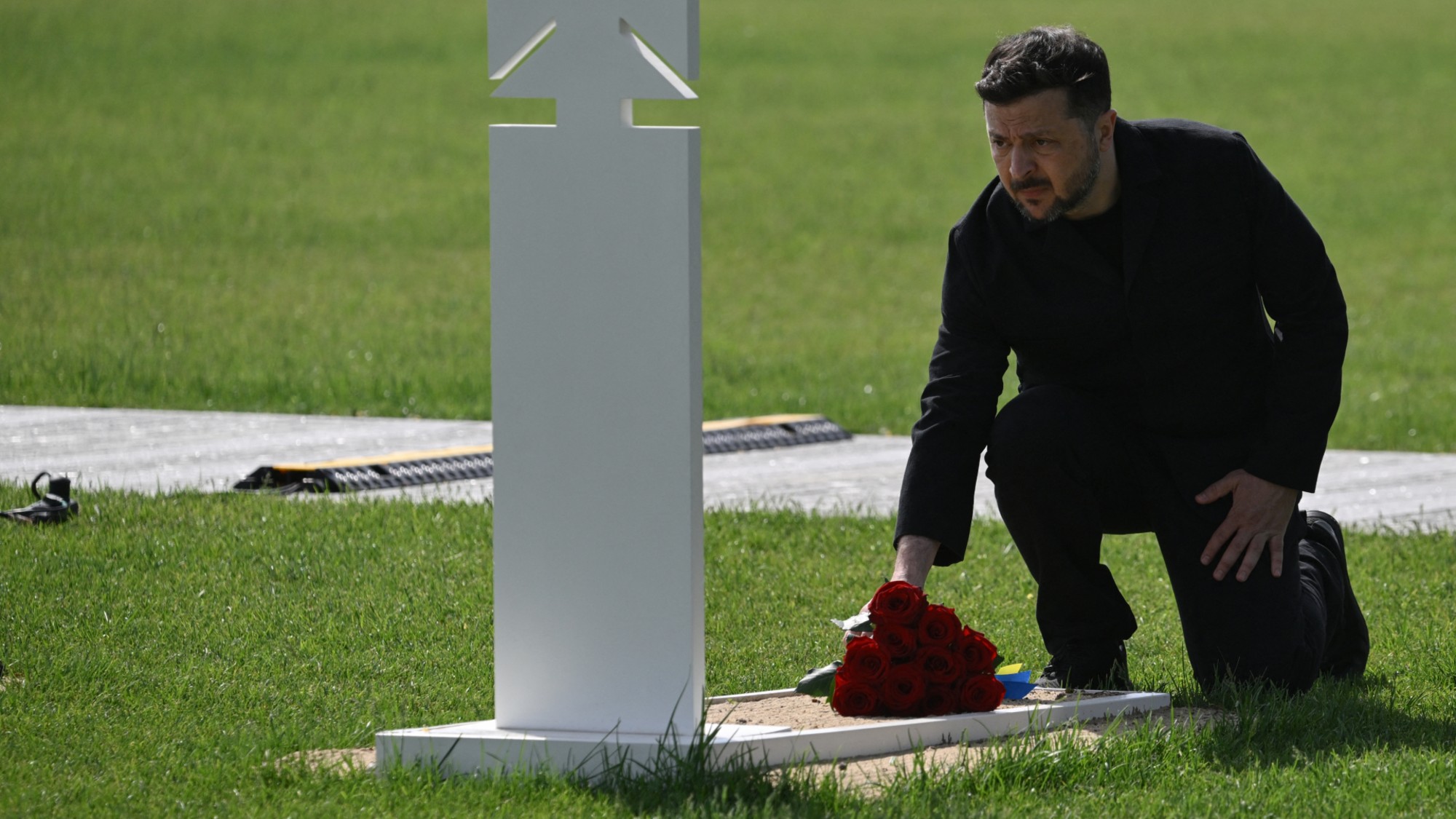Ukraine's President Volodymyr Zelensky lays flowers at the grave of a fallen Ukrainian soldier during a ceremony at the National Military Memorial Cemetery near Kyiv