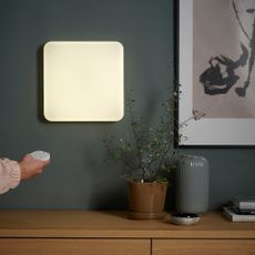 IKEA JETSTRÖM LED wall light panel on a wall, someone turning it on using a remote control