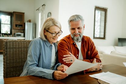 Mature couple going over paperwork at home together