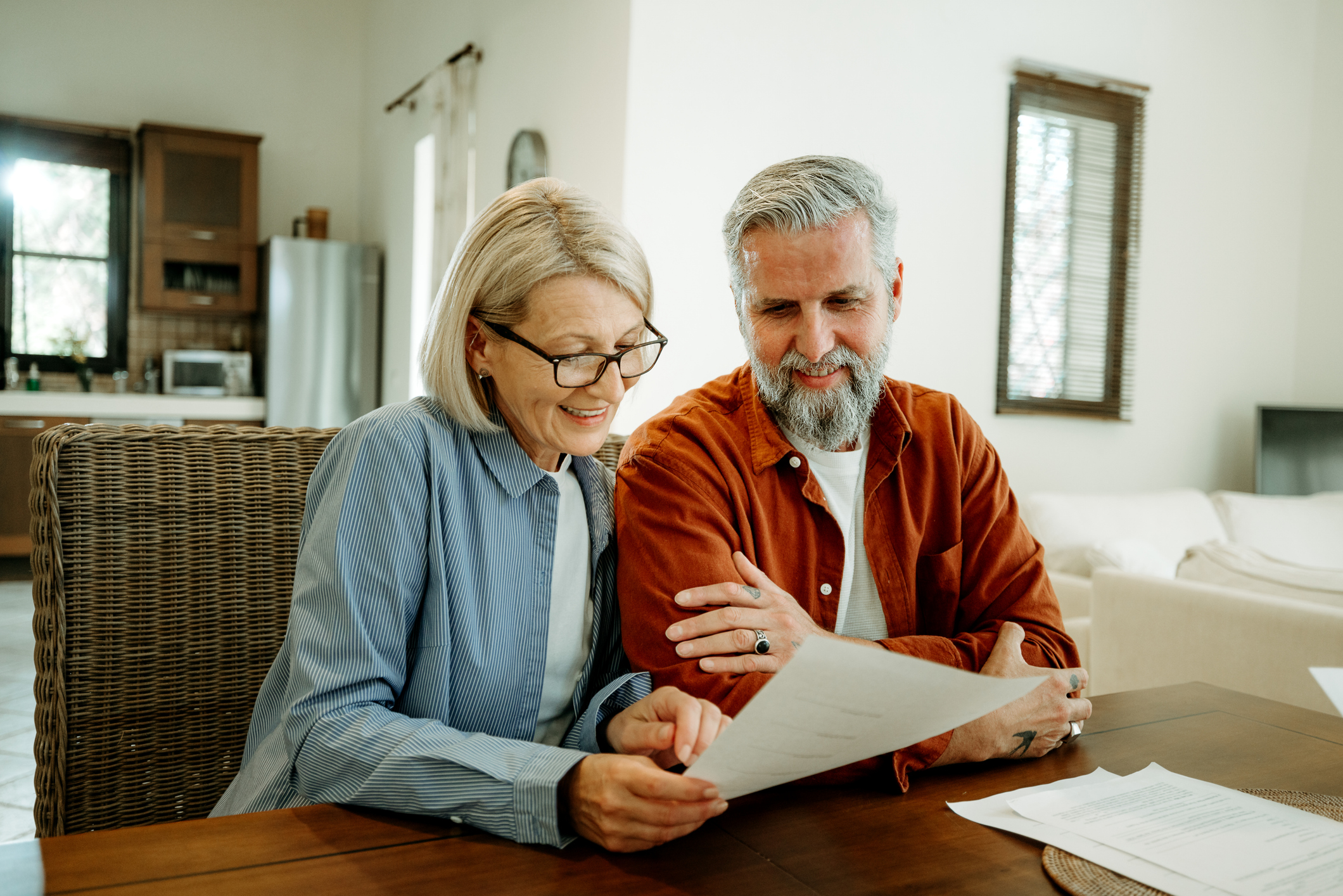 Mature couple going over paperwork at home together