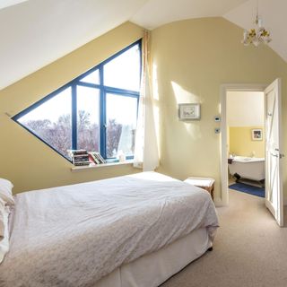 attic bedroom with cream walls and shaped window