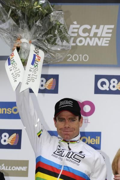 Evans lifts the bouquet and gives a small grin on the podium.T