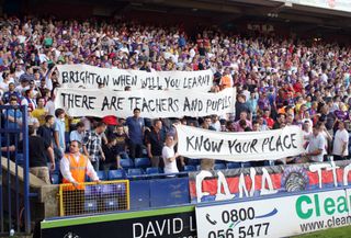 Crystal Palace fans, at a 2011 match vs West Ham, hold up banners mocking Brighton