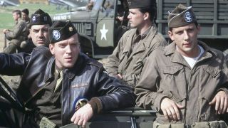 Members of Easy Company sitting in, and standing by, a car in Band of Brothers