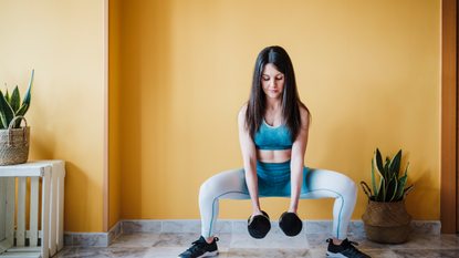Woman squatting with dumbbells