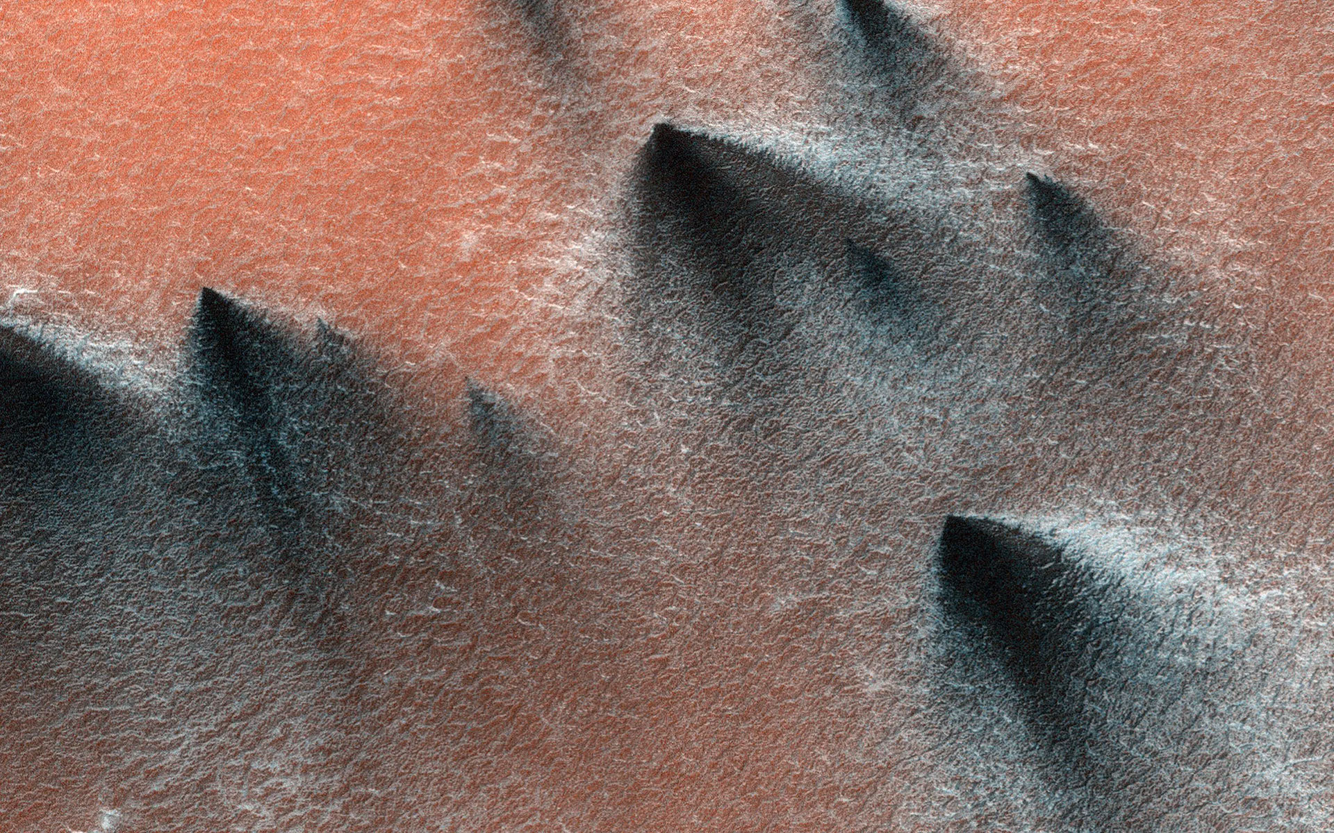 dark debris from under the martian surface is carried up by bursts of gas