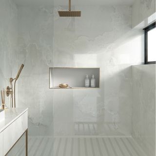 Shower storage ideas with marble walls and gold fittings