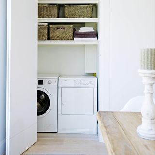 white wall with washing machine and baskets with napkins