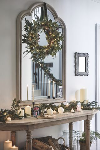hallway with Christmas wreath and console table with foliage