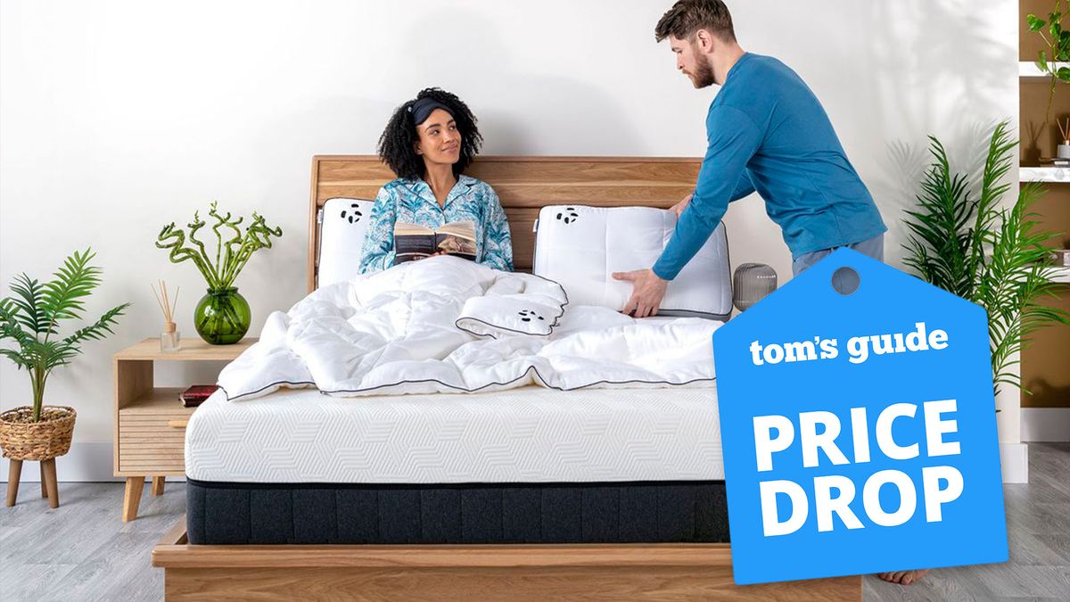 A couple laugh while the woman lies on the Panda Hybrid Bamboo Mattress Pro, set on a wooden bed frame, with a blue price drop sales badge overlaid in the bottom right corner