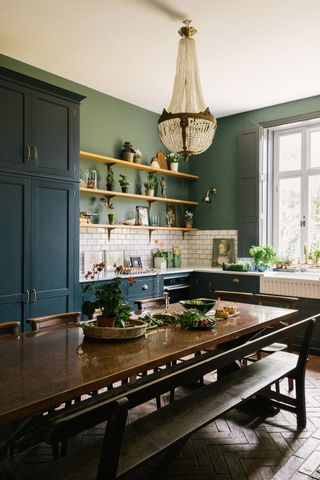dark blue kitchen with L shape layout and dining table