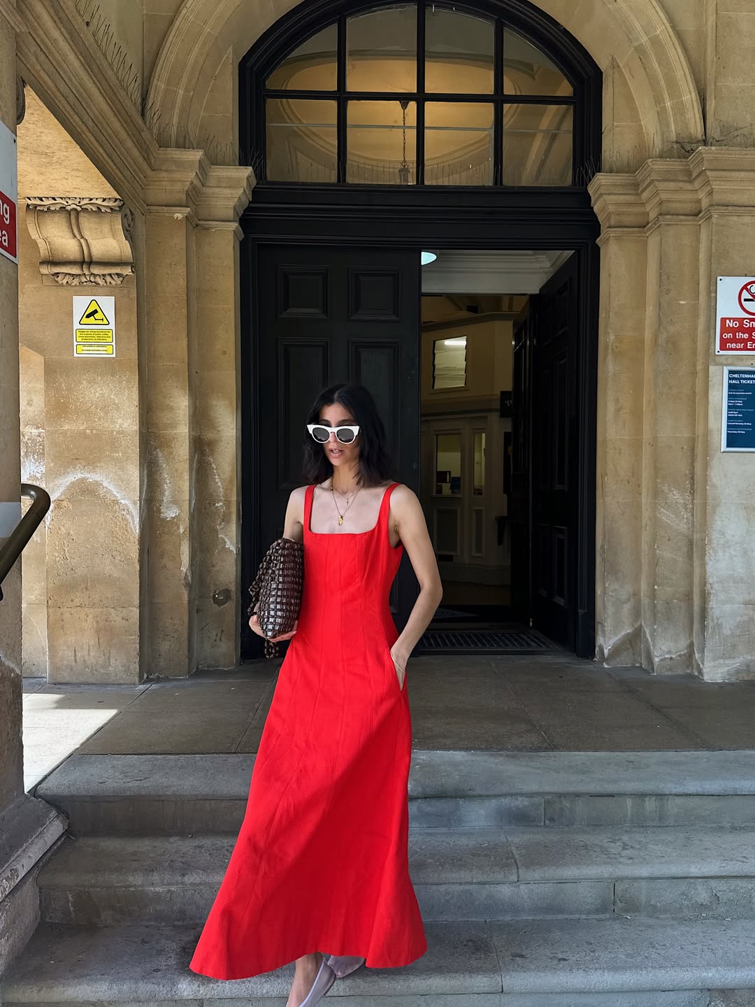 Influencer Santina Harrison wearing a red dress with mesh ballet flats and a beaded bag.