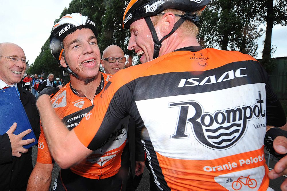 Berden de Vries congratulates teammate Dylan Groenewegen on the win.